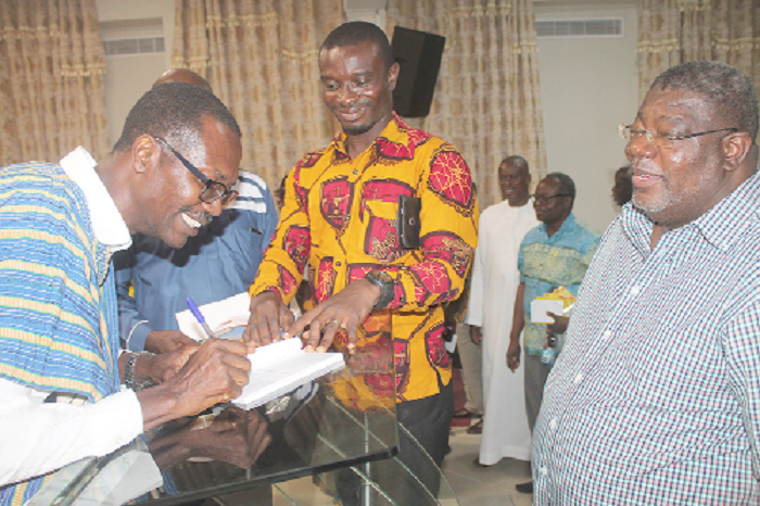 • Mr Benjamin Aryee (left) autographing some of the books for participants after the launch. Picture: EDNA ADU-SERWAA
