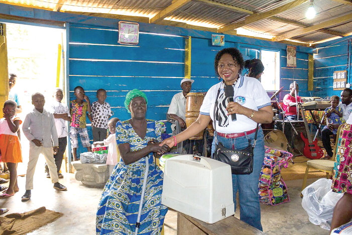 • Dr Walley-Daniels presenting an item to one of the beneficiaries