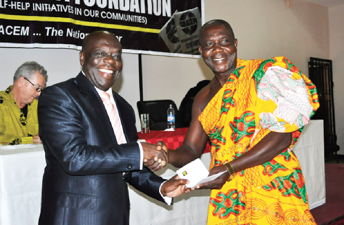 Nana Prah Agyensaim VI (left) hands over cement allocation letter to representative of a beneficiary Institution
