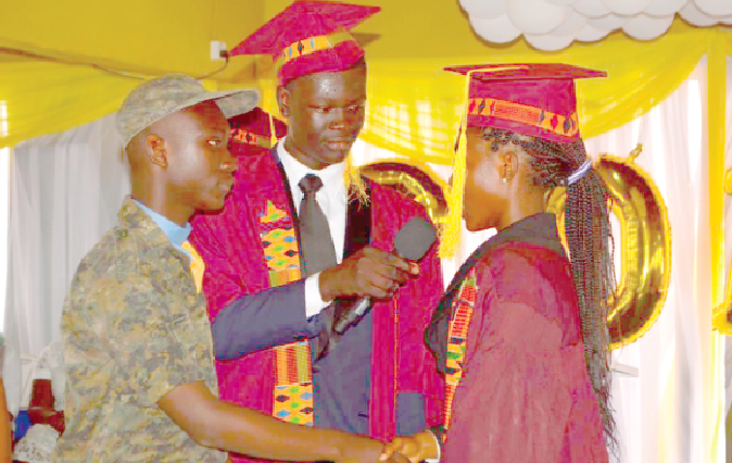 The outgoing head prefect, Miss Sharon Gandaa (right), handing over the baton to Mr Brian Dougan