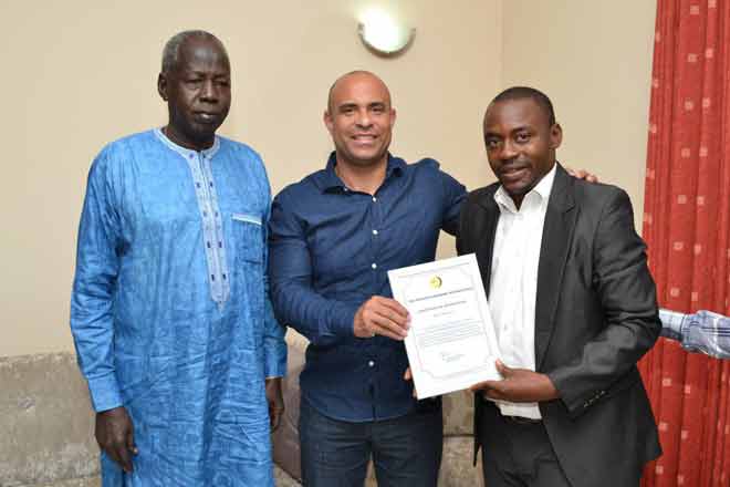 Mr Yahaya Alhassan, Chief Executive Officer of the Humanity Magazine presenting the award to Mr Laurent Savaldor Lamothe (middle). On the right is Mr Michael Chol, the South Sudan Ambassador to Ghana.