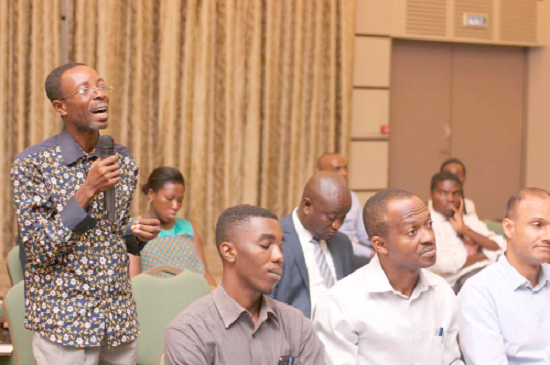A participant asking a question at the seminar