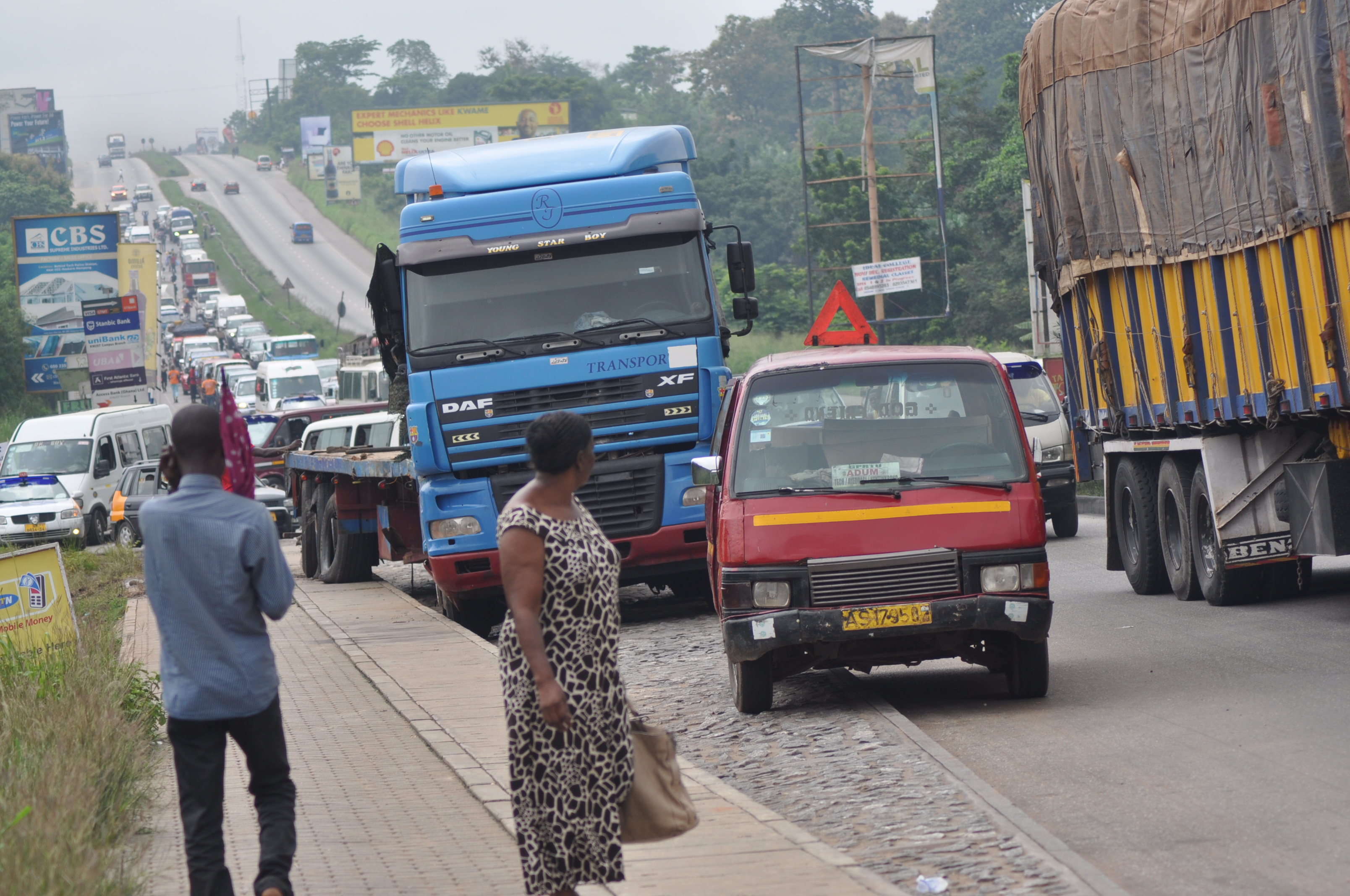 The police controlling traffic  jam on the Kumasi -Accra highway , as a result of an abandoned broken down vehicle