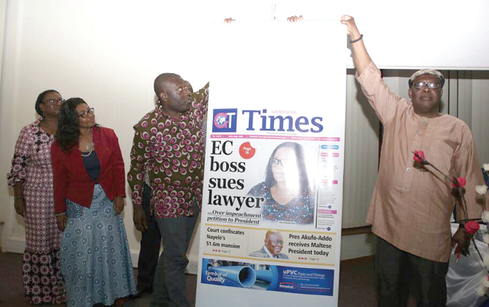 A deputy Minister of Information, Mr Kojo Oppong-Nkrumah, being assisted by the Chairman of NMC, Nana Kwasi Gyan-Appenteng to unveil the new look Ghanaian Times. Looking on are the Board Chairperson, Mrs Margaret Rose Kpodo, and the MD, Ms Carol Annang