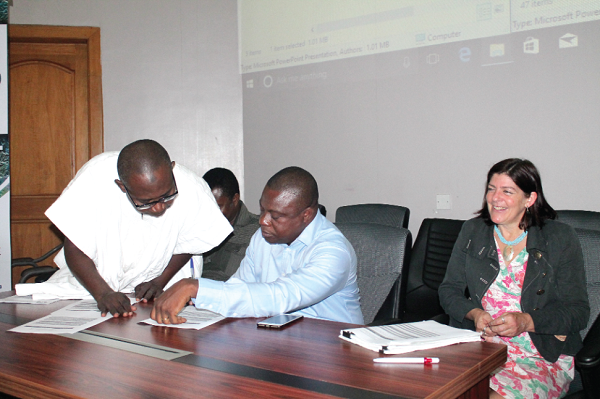 Mr John Allotey (2nd left) and Mr Yakubu Mohammed (left), Manager, Geographic Information Systems and Mapping at Forestry Commission, looking through some documents at the event. With them is Dr Ruth Malleson (3rd left), Manager of the Forests 2020 project.  Picture: Maxwell Ocloo