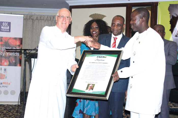 Mr Salifu Saeed (right) honouring Father Andrew Campbell (left) on behalf of FRAGO while Dr Sagre Bambangi looks on