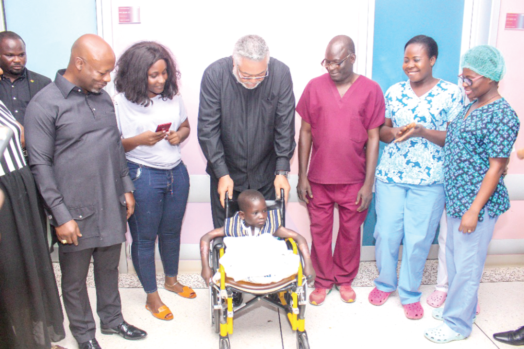 President Rawlings with Peter Mensah while  Madam Anita Sefa Boakye (third left) and other hospital staff look on