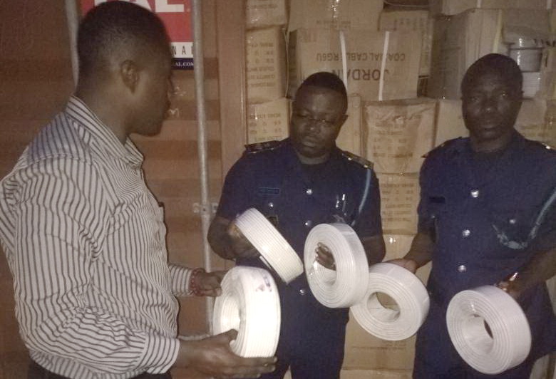 Customs officers showing some of the fake electrical cables to Kester Aburam Korankye of the Daily Graphic