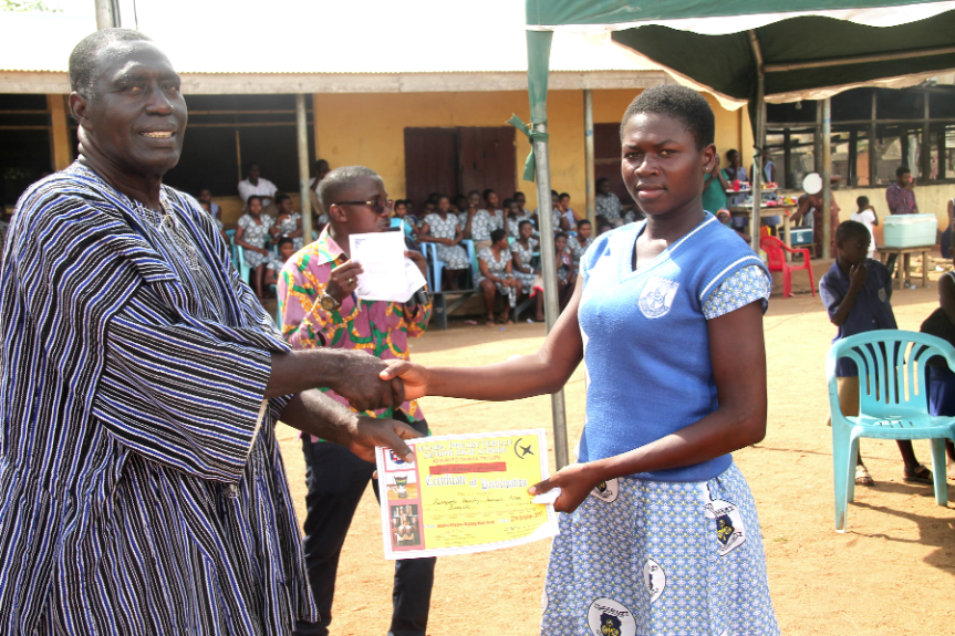 Mr David Aning Yebo (left), Headmaster of NPSHS,  presents another certificate of participation to a representative of the Kwanyarko Senior High School.