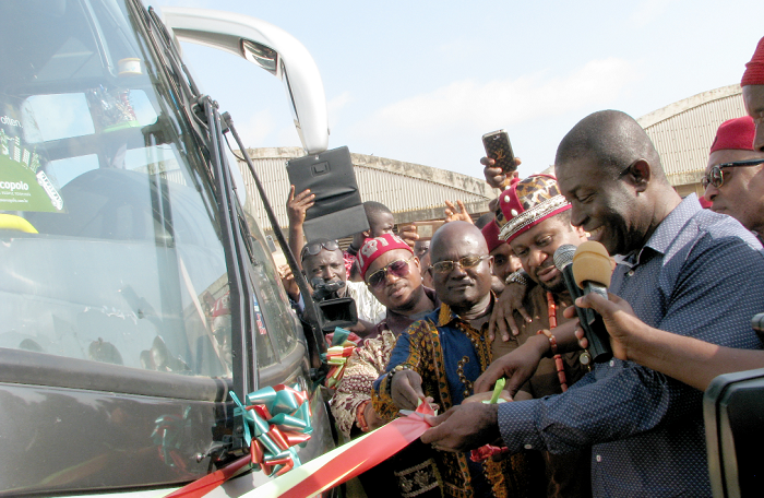  Nana Akomea (right)  being assisted by Eze (Dr) Ambassador Chukwudi Jude Ihenetu (2nd right)  to cut the  tape to inaugurate a new State Transport Corporation bus.Picture:ESTHER ADJEI 