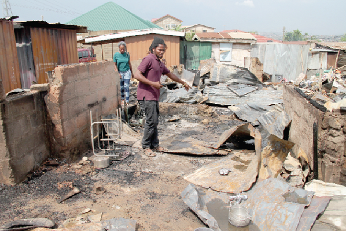 The father of the deceased, Mr Hope Tagborlo, pointing to the spot where the deceased was found after the fire outbreak. Picture: EDNA ADU-SERWAA