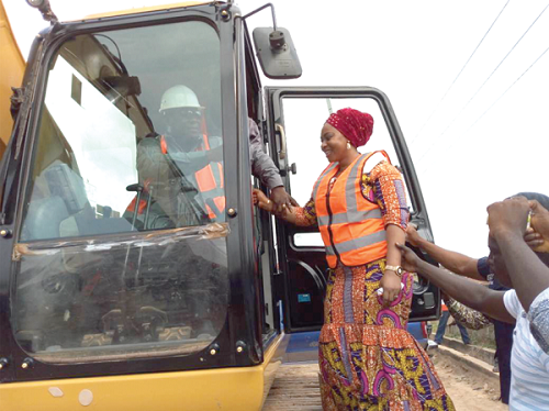 Mr Amoako-Attah moving a tractor to symbolically start the project. With him is Ms Sarah Adwoa Safo, Member of Parliament for Dome-Kwabenya