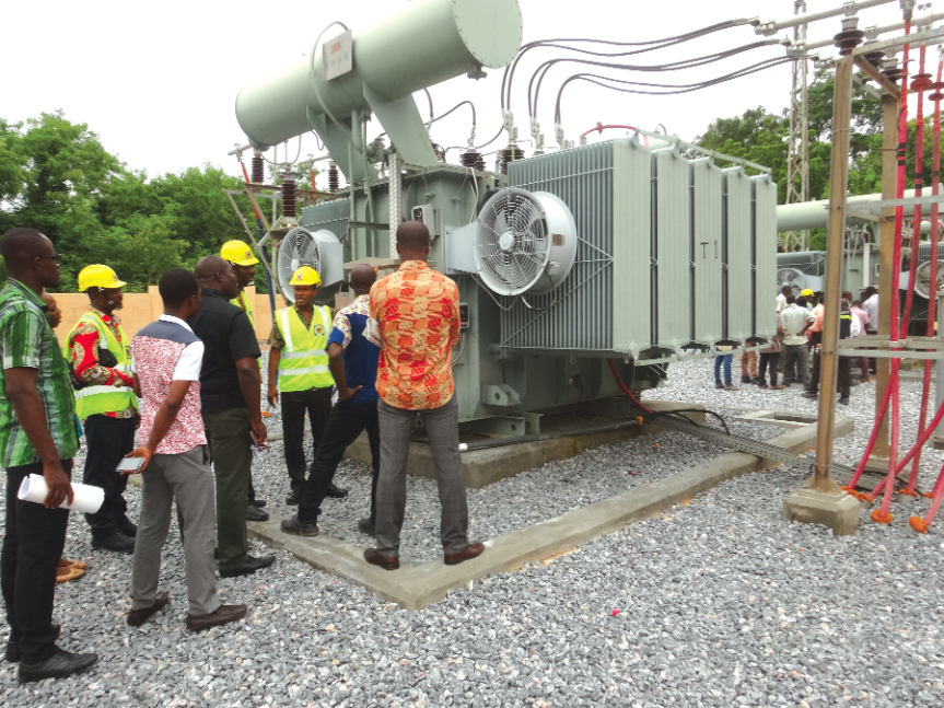 An engineer of the ECG, Mr Festus (3rd from right) explaining the functions of one of the transformers at the primary substation.