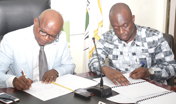 Dr. Nana Ato Arthur (left), Head of the Local Government Service and Mr Justin Koduah Frimpong, Chief Executive Officer of the Youth Employment Agency  signing the MOU at a ceremony in Accra. Picture: GABRIEL AHIABOR