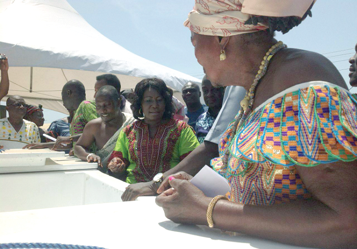 Mrs Elizabeth Afoley Quaye (2nd right) inspecting one of the insulated fish containers. (INSET): The minister handing over the containers to Madam Awon Golga of the Tema Fish Processors and Traders Association. Picture: Benjamin Xornam Glover