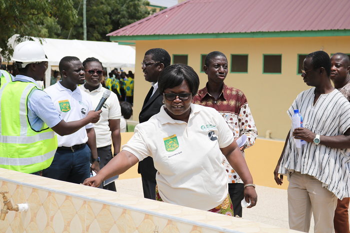 The Headmistress of Odorgonno SHS opening one of the taps 