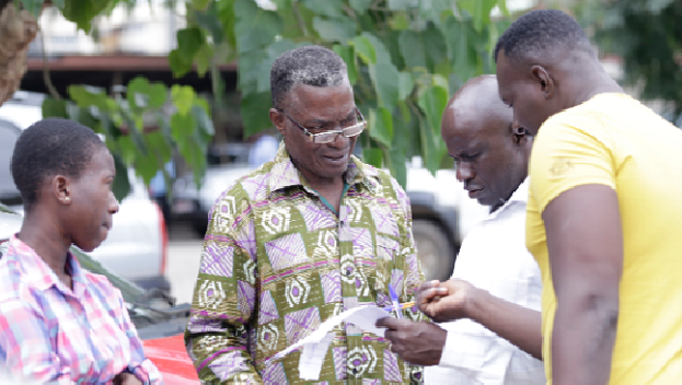 A parent (middle) and a daughter (left), explaining a point to Mr Severious Karle Dery (2nd right), Staff Writer of the Daily Graphic at the Ministry of Eduction in Accra on Monday. Picture: EMMANUEL ASAMOAH ADDAI  