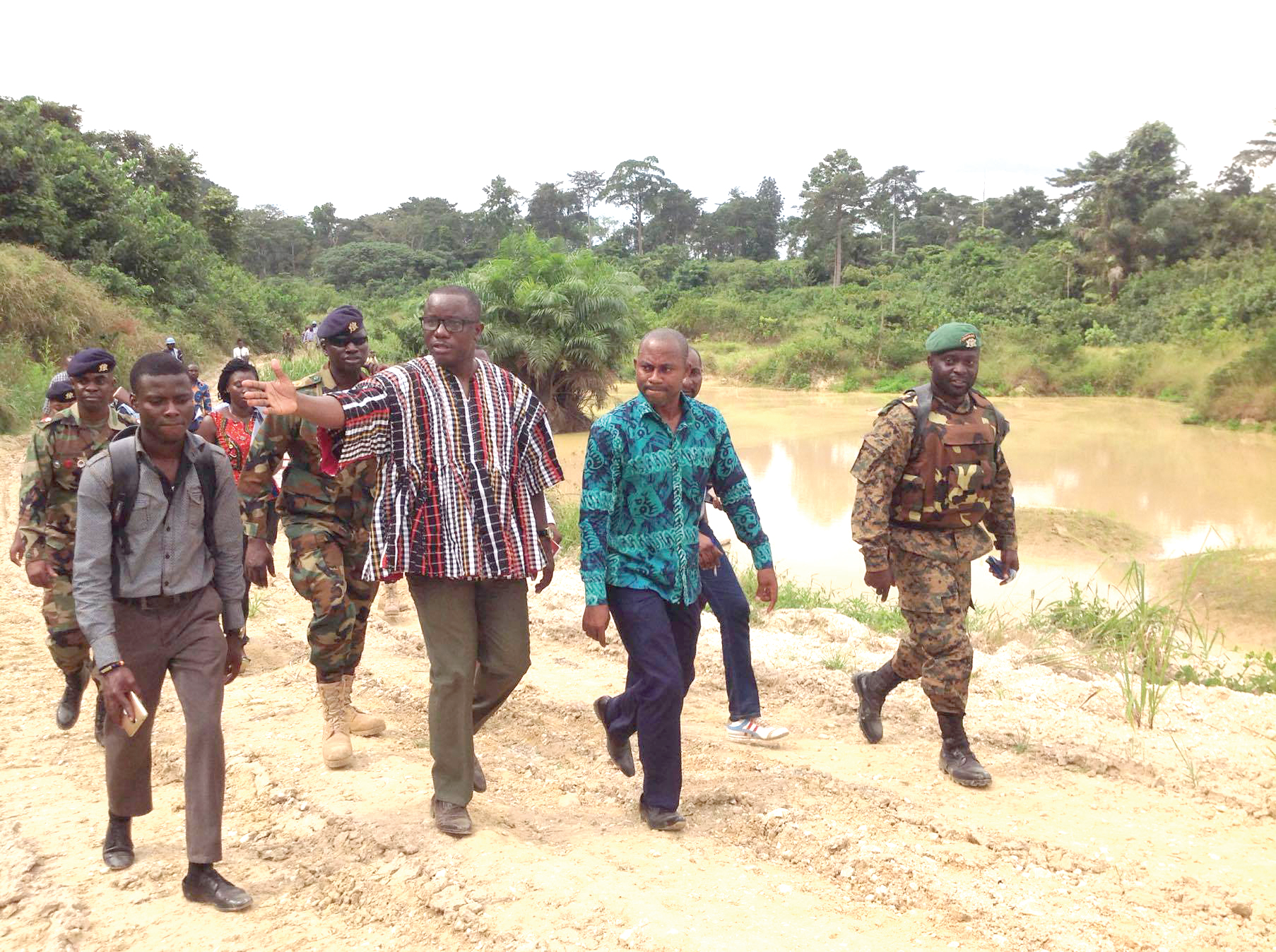 Mr Dominic Nitiwul (in smock) being conducted round a galamsey site in Tarkwa