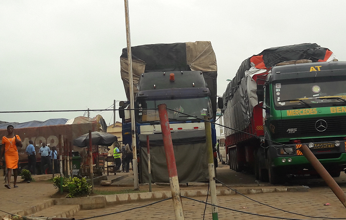 Some transit trucks parked at the Ghana side of the border awaiting documentations on their cargoes. 