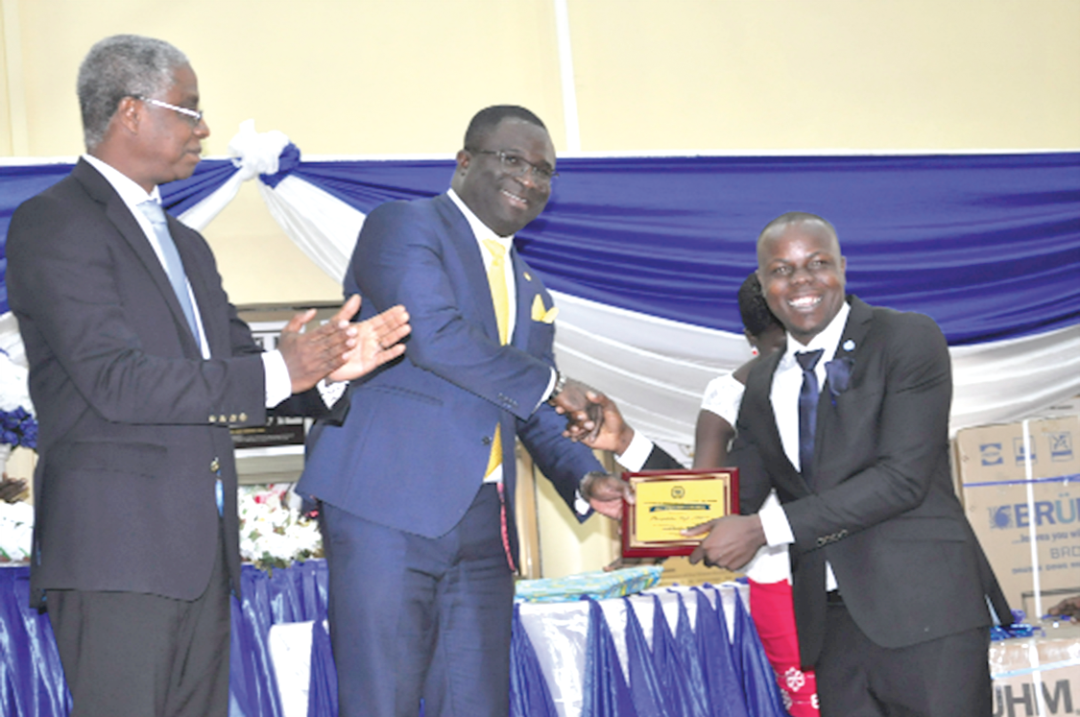 Mr Eugene Boakye Antwi (middle), the Deputy Minister of Works and Housing, handing over a memento to Mr Theophilus Kofi Attipoe, Overall Best Candidate. Looking on is Mr Joseph E. Hayford