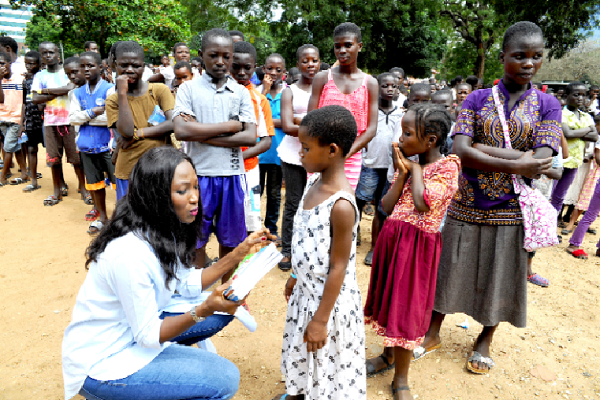  Miss Sheila Azuntaba, presenting  the books to one of the children