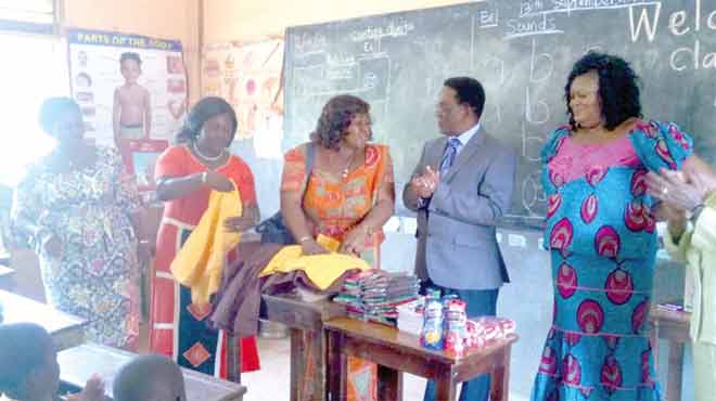 Prof Yankah (2nd right) admiring some of the free school uniforms meant for the children while some officials examine them at the La Bawaleshie Presby Basic School