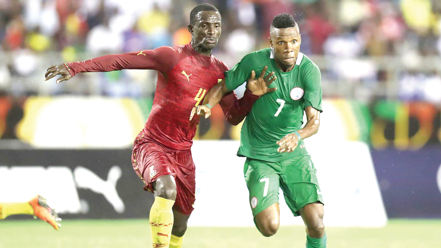  Ghana defender Emmanuel Ampiah in a tussle with Nigeria forward John Ubony Friday