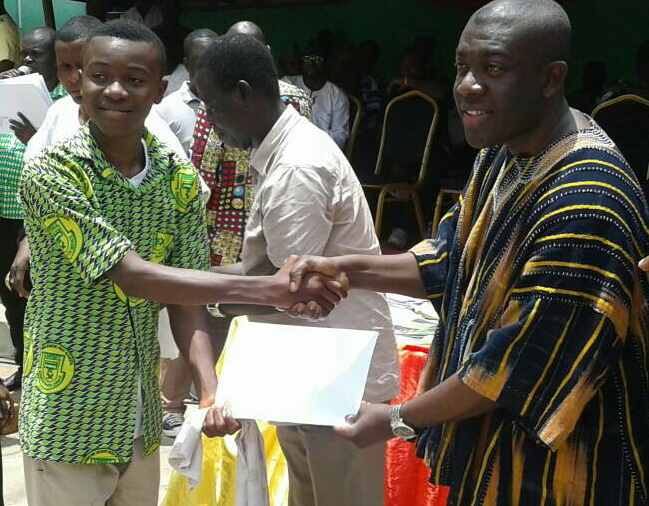 Mr Oppong Nkrumah handing over the scholarship package to one of the beneficiaries