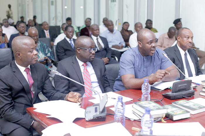 Mr Isaac Asiamah (middle) answering questions at the PAC