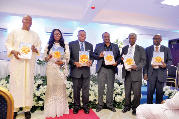 Prof. Josuah Alabi (left) with Prof. Goski Alabi (2rd left) and other dignitaries displaying the book at the launch