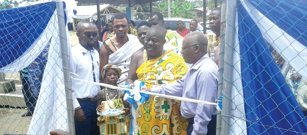 Nana Akye Blay, Chief of Menzezor, and Mr Charles Darko (right), MD, Tullow Ghana, cutting a tape to officially hand over the water system. 