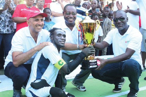 Mr Albert Frimpong (right) handing over the cup to the skipper of Rockets, Gariba Sani
