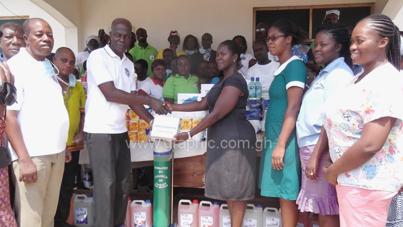 Nana Tsibu Danso of the Tema New Town congregation of the Church of Christ in a handshake with Ms Ruby Aboagye of the Tema Manhean Health Centre during the presentation of assorted items while staff of the facility and members of the church look on.