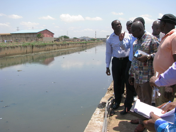 Mr Samuel Atta Akyea (2nd right) inspecting  dredging works in some drains in Accra