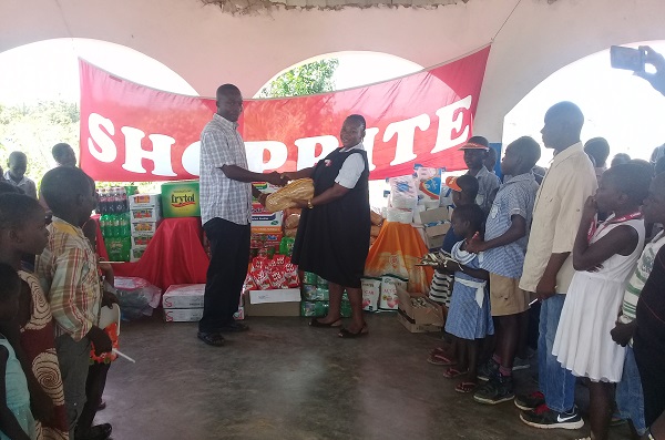 Mrs Rossina Abgalega, Front Admin. Manager at Shoprite, presenting the items to Mr Samuel Kwapong Darko, Founder of the Eye of the Lord Orphanage 