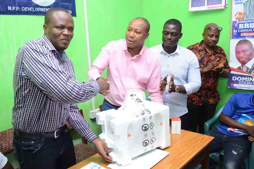 The AAK NPP constituency chairman, Mr Kweku-Baah Ewudzie (left) receiving the items from the Central Regional First Vice chairman aspirant and industrialist, Mr Horrace Ekow Ewusi. Looking on are some executive of the party.