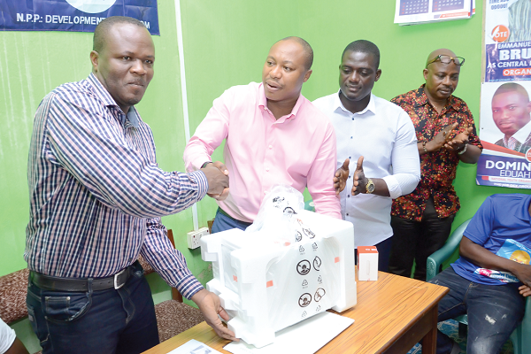 Mr Kweku-Baah Ewudzie (left), the AAK NPP Constituency Chairman, receiving the items from Mr Horace Ekow Ewusi, the Central Regional First Vice-Chairman aspirant and industrialist. Looking on are some executive members of the party