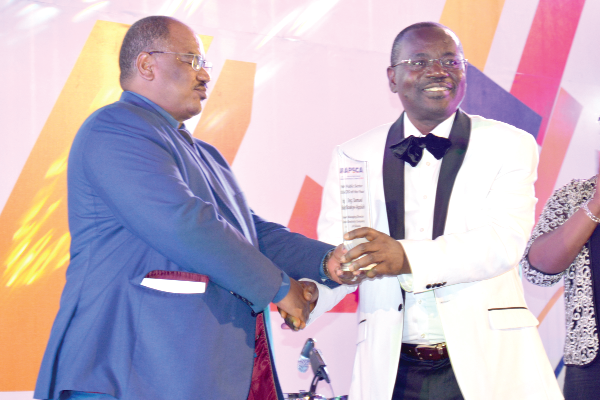 Mr Samuel Boakye–Appiah (right), the Managing Director of the Electricity Company of Ghana (ECG),  receiving the award from one of the organisers of the event