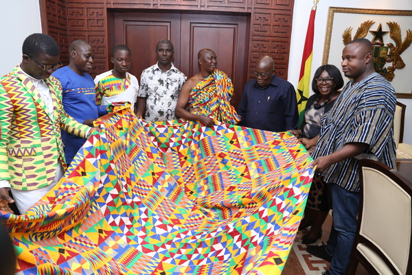 President Akufo-Addo admiring the kente presented to him by the delegation from the Kente Weavers and Sellers Association at the Jubilee House in Accra