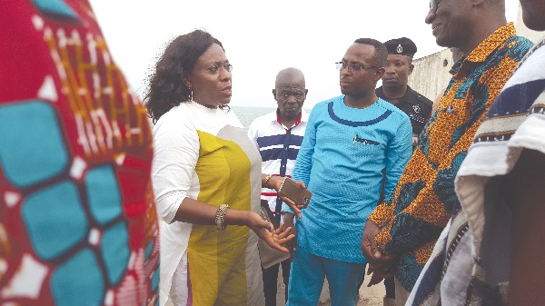 Mrs Catherine Afeku (left) in a chat with Mr Kwamena Duncan (right) and other officials on open defecation
