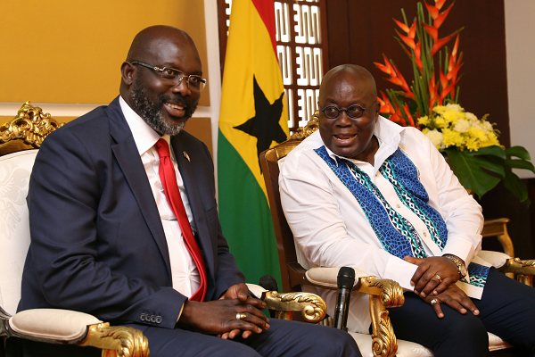 President Akufo-Addo in a hearty chat with his Liberian counterpart at the Jubilee House. Pictures: SAMUEL TEI ADANO