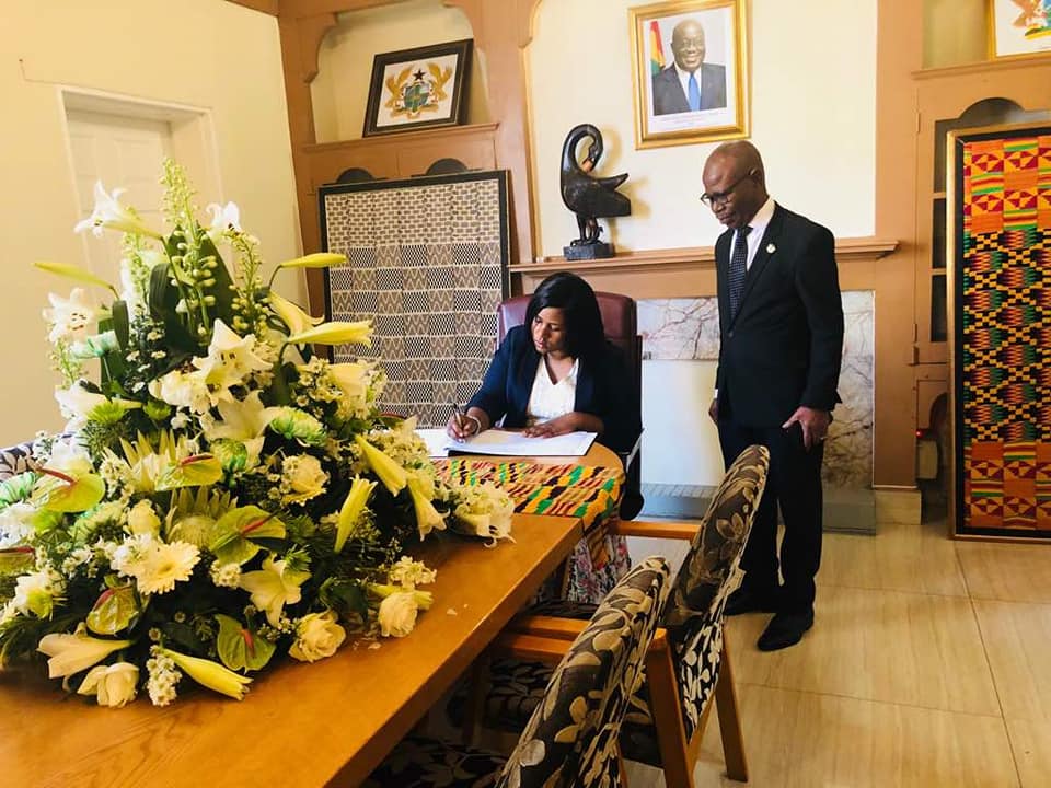 Ms. Babara O. Neresa, the Ugandan High Commissioner to South Africa , signing the book of condolence at the Ghana Mission in Pretoria. Looking on his Mr George Ayisi-Boateng, Ghana's High Commissioner to South Africa.