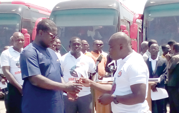 The Board Chairman of the Metro Mass Transit (MMT) Limited, Mr Ahmed Arthur (right), presenting the keys of the buses to the acting Managing Director of the company, Mr Albert Adu Boahen