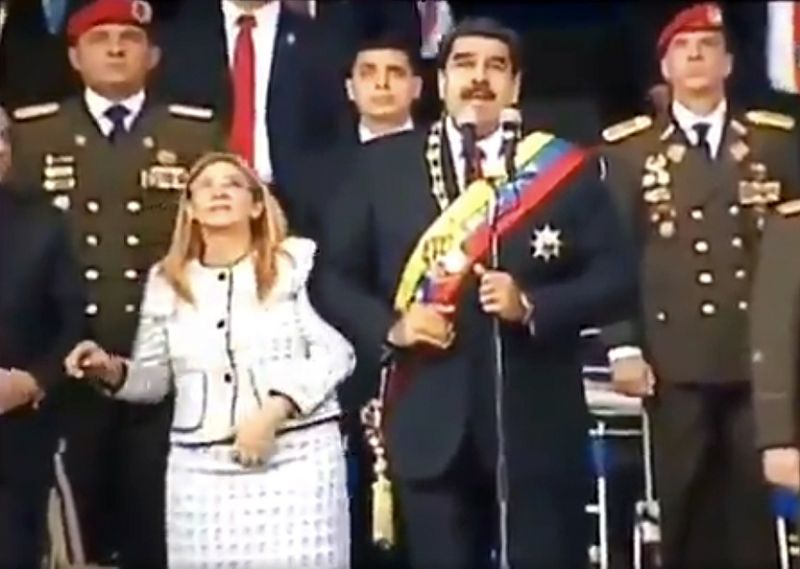 President Maduro (centre) and his wife Cilia Flores (left) react to a loud bang during the military event