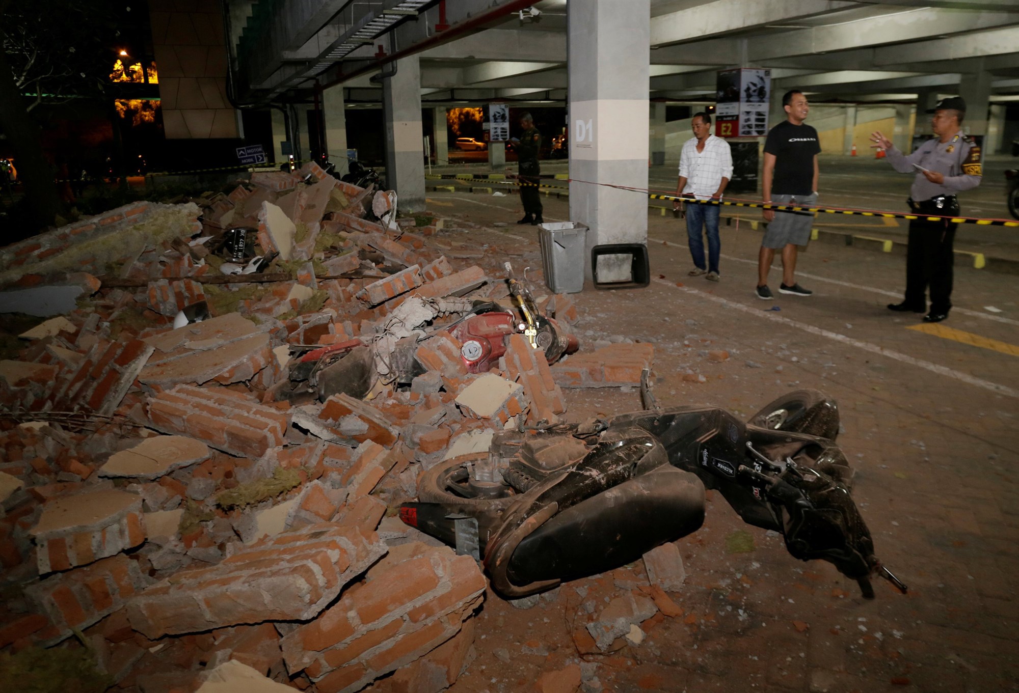 Police examine debris that crushed motorbikes Sunday at a shopping center in Kuta, Bali, Indonesia, following a strong earthquake on nearby Lombok island.Johannes Christo / Reuters