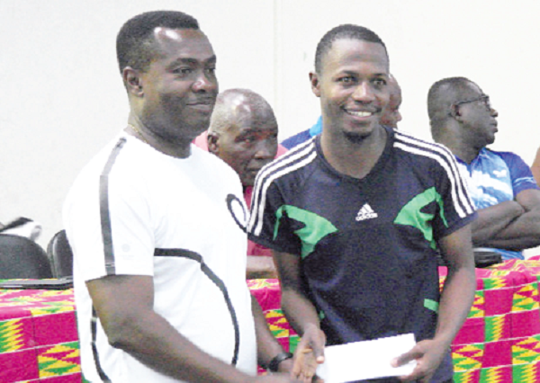 Ayodele receiving his reward from Mr Afadzinu (right)