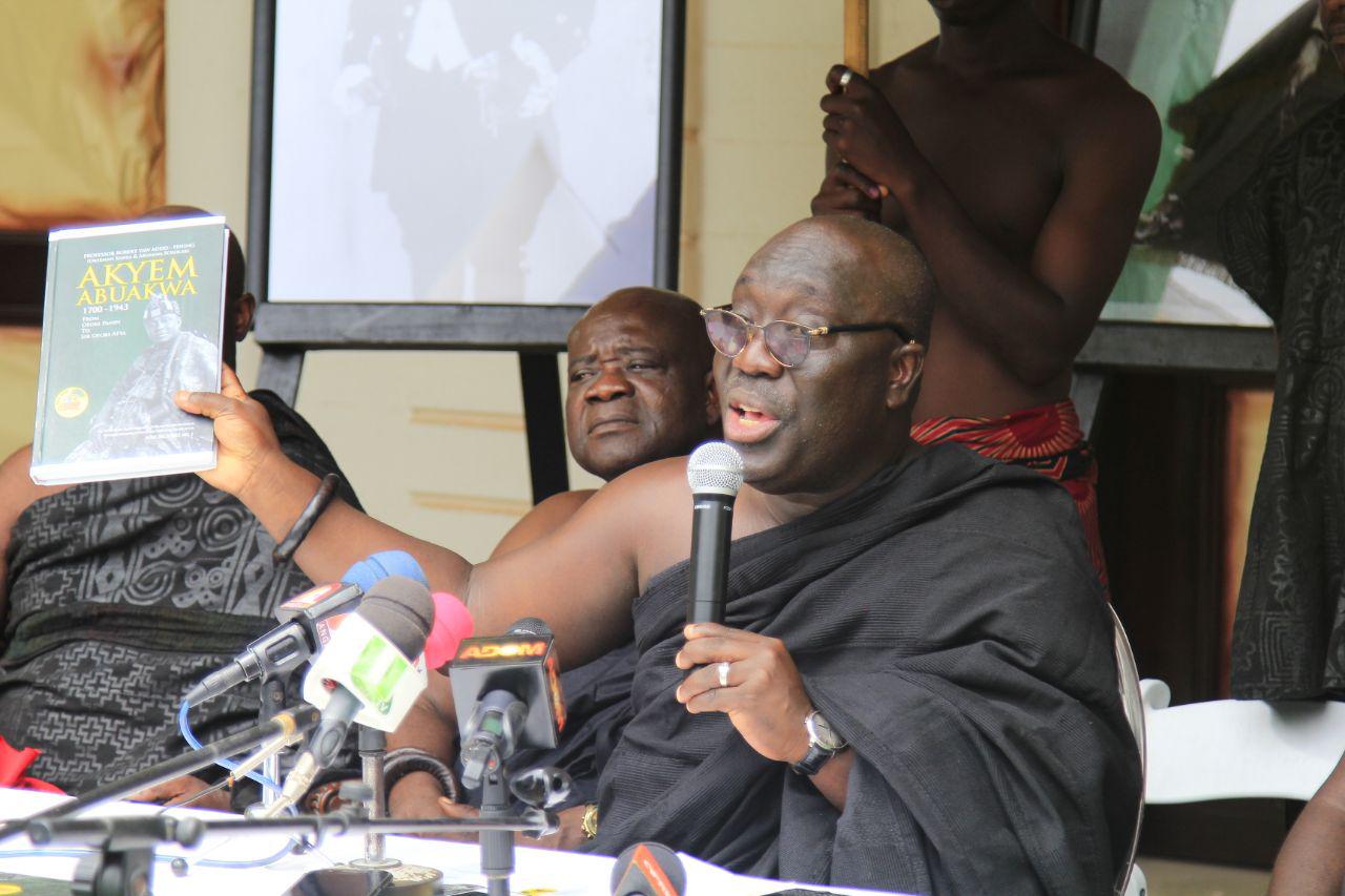 Barima Kwaku Dua (right), Etwienana Hene and Chairman of the Planning Committee, showing a history book of Nana Sir Ofori-Atta to the chiefs and guests at the launch