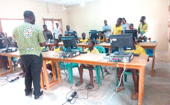 Mr Thomas Heyford Ofosuhene (back to camera), one of the leaders of the year group, speaking to some pupils in the ICT centre after the official inauguration