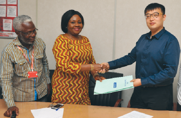 Mrs Mavis Kitcher , Acting Director, Newspapers of GCGL, and Mr Wang Bozun, the Editor of the Global Times,  exchanging notes after signing the agreement on behalf of their respective organisations. With them is Mr Kingsley Inkoom (left), Acting Editor of the Daily Graphic 