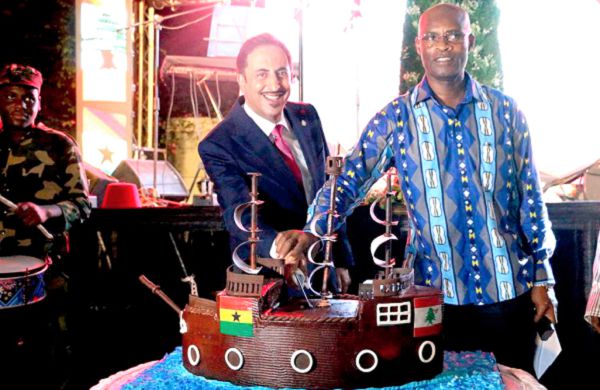 The Lebanese Ambassador to Ghana, Mr  Maher Kheir (left), being assisted to cut the anniversary cake by Mr Adam of the Ministry of Foreign Affairs